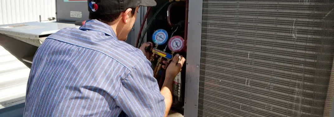 HVAC technician servicing a condenser unit in Rowlett